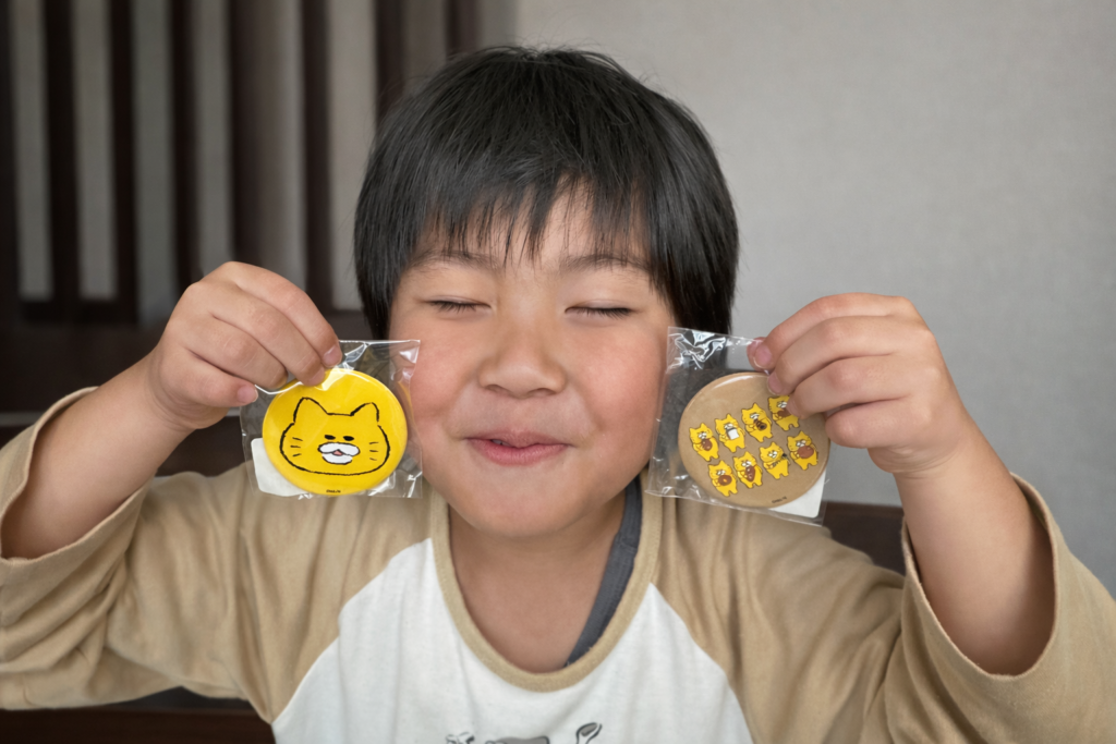 佐賀城下ひな祭りにて、買ってもらった、のらねこ軍団の缶バッジの真似をする息子の写真です。